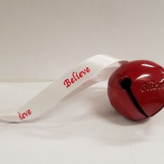 a red apple with a white ribbon attached to it's core and the word love is written on its side