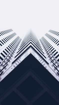 an upward view of some tall buildings in the city with blue and white colors on them