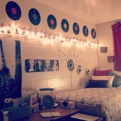 a bed room with a neatly made bed and lots of decorations on the wall above it