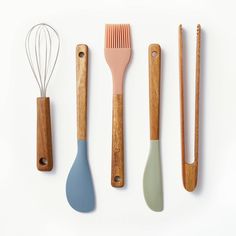 various kitchen utensils lined up on a white surface