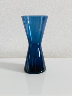 a blue vase sitting on top of a white table