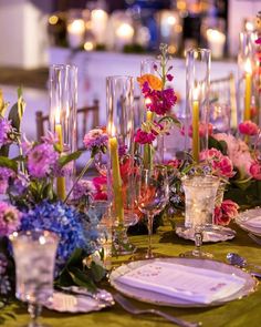 the table is set with flowers and candles