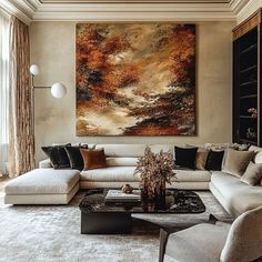 a living room filled with furniture and a large painting on the wall above it's fireplace