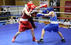 two men in red and blue boxing outfits, one is hitting the other with his gloves