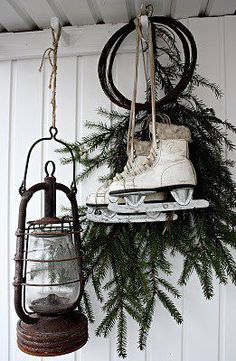 a pair of ice skates hanging from the side of a wall next to a lantern