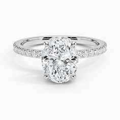 an oval cut diamond engagement ring with pave set shoulders