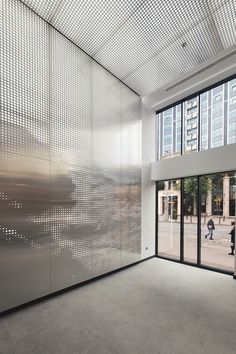 an empty room with large glass doors and people walking by