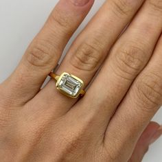 a woman's hand with a gold and white diamond ring on top of it