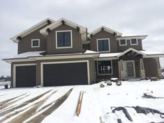 a house with snow on the ground and two garages