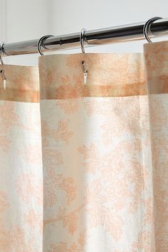 an orange and white curtain hanging from a metal rod