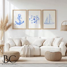 a living room filled with white furniture and paintings on the wall above it's couch