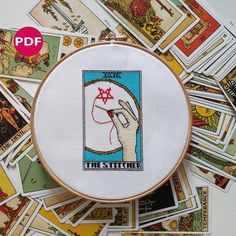 the cross stitch pattern is on top of some cards and has a hand holding a star