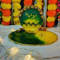 there is a sign that says haldi mehandi on the table with lights around it