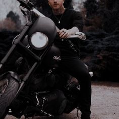 a man sitting on top of a black motorcycle