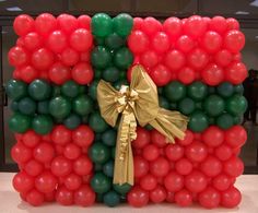 balloon art made to look like the flag of kenya with gold ribbon and bow on it