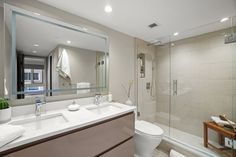 a bathroom with two sinks, a toilet and a walk - in shower next to it