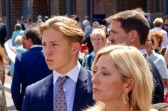 a group of people standing next to each other in front of a building with many others