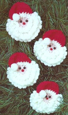 three crocheted santa clauss sitting in the grass with their eyes wide open