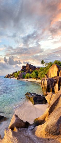 the beach is surrounded by large rocks and water