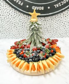 a fruit platter with a christmas tree on it's top and berries in the middle