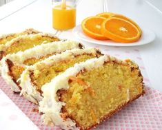 slices of orange cake sitting on top of a pink napkin next to an orange slice