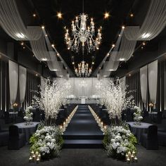 an elegant black and white wedding setup with chandeliers, flowers, and candles