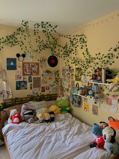 a bedroom with plants growing on the wall and pictures hanging above the bedspread