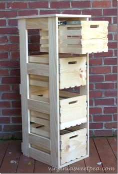 a wooden crate sitting on top of a wooden floor next to a brick wall