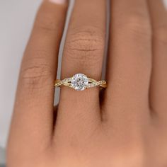 a woman's hand with a diamond ring on top of her finger and an engagement band