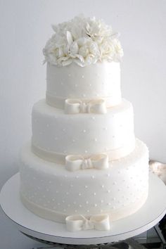 a three tiered wedding cake with white flowers on top