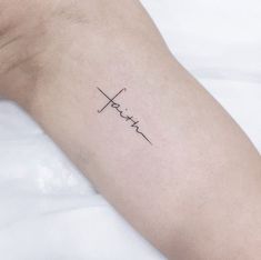 a person's arm with the word faith written in cursive writing on it