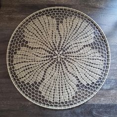 a white doily sitting on top of a wooden table