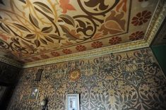 an ornately painted ceiling in the corner of a room with a mirror and light fixture