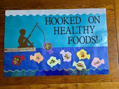 a sign that says hooked on healthy foods with fish and flowers in the water next to it