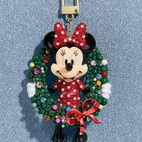 a mickey mouse keychain with a christmas wreath around it's neck and ears