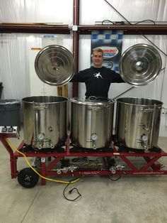 a man standing in front of some metal tanks