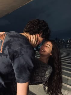 a man kissing a woman on the cheek in front of an empty bleachers