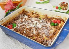 a blue casserole dish filled with food on top of a table