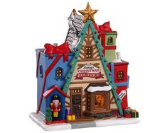 a christmas village is shown with presents on the roof and in front of it's store