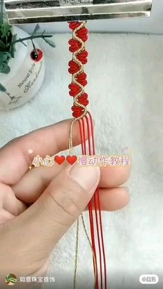 a person holding a red string with hearts on it