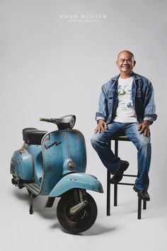 a man sitting on top of a blue scooter