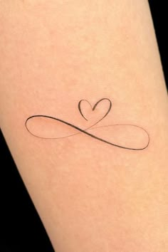 a heart shaped tattoo on the leg with an infinite love symbol in it's center