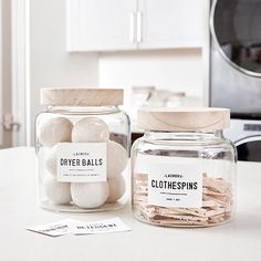 two glass jars filled with white balls on top of a counter