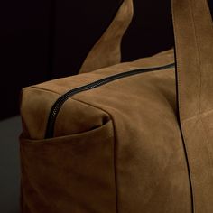 Our modern and sleek duffle bag is made from Italian calf suede with contrast hand glazed edges and is functionally designed, becoming the essential every day or travel ready bag. Additional Information:• Italian Calf Suede • Fully lined with internal zippered pocket• Side Welt Pockets• Length: 21.8", Width: 8.6" Height: 15.75"• Top Handle Drop: 9"• Removable Grosgrain adjustable shoulder strap Modern Suede Satchel For Travel, Modern Leather Duffle Bag For Daily Use, Modern Suede Shoulder Bag For Travel, Modern Leather Duffle Bag With Leather Lining, Modern Everyday Duffle Bag With Leather Backing, Brown Business Bag With Suede Lining, Modern Leather Duffle Bag For Everyday, Modern Duffle Bag For Daily Use With Leather Lining, Modern Weekender Bag With Leather Backing