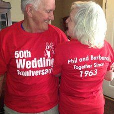 two older people wearing red shirts standing next to each other