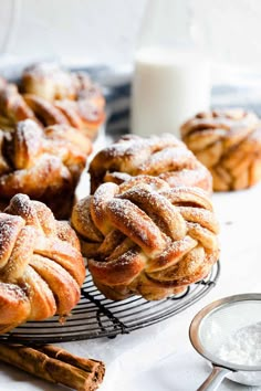 the best twisted cinnamon buns on a wire rack with powdered sugar in the background