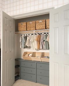 an organized closet with baskets and clothes hanging on the wall, next to two doors