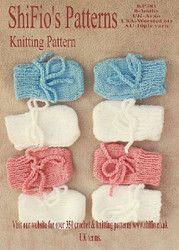 three knitted bows on top of each other in white and blue, with pink trims