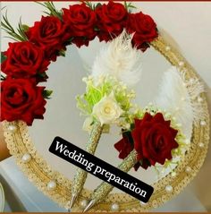 wedding preparation with red roses and white flowers in front of a mirror on the wall