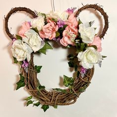 a wreath with flowers and greenery hanging on a wall